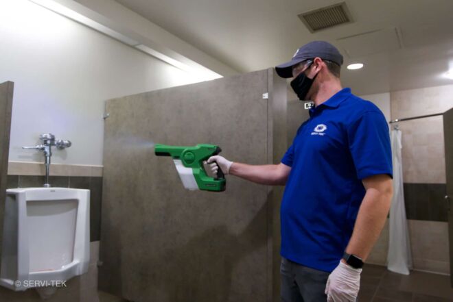 janitor disinfecting urinal