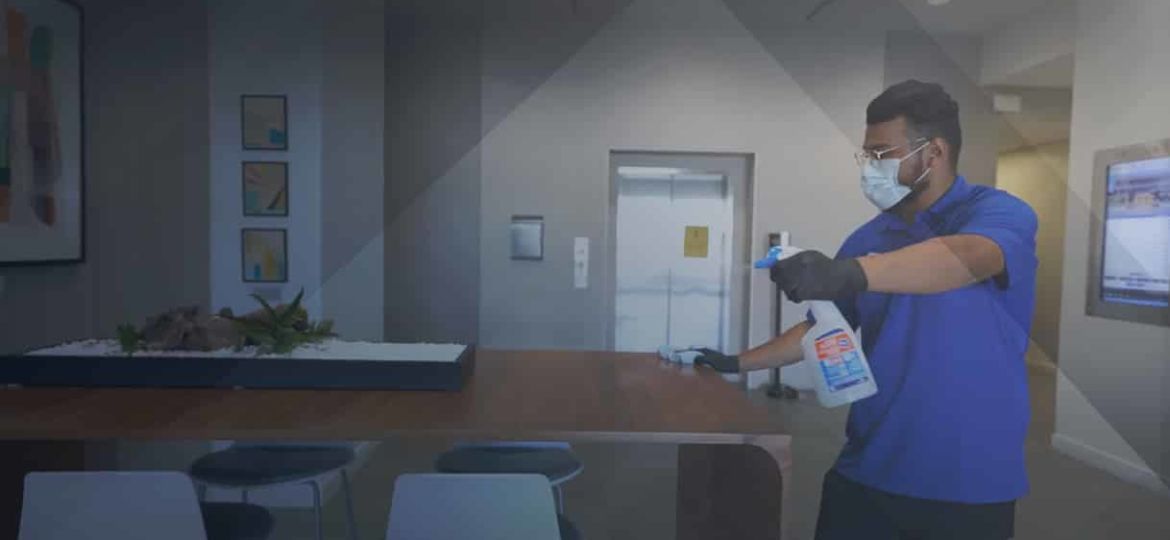 A Janitor cleaning an office table