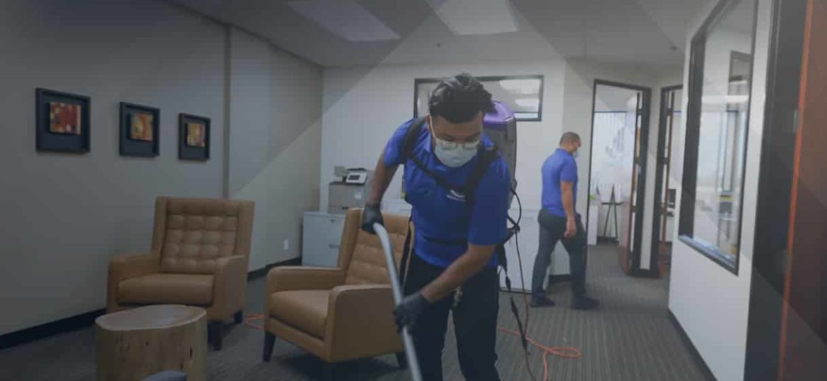 Two men cleaning the room with vacuum